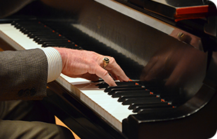 An adult student playing the piano