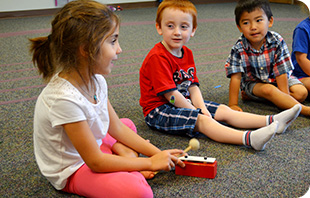 Three young students enjoy an Early Childhood class